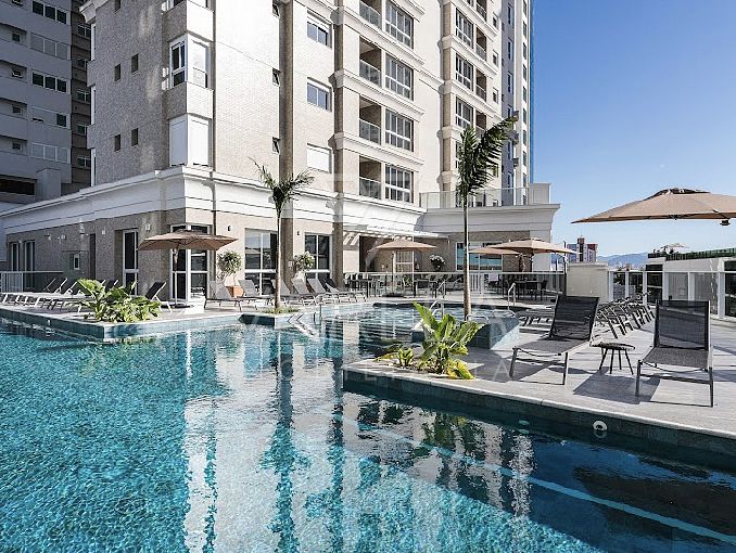 Área de lazer entregue em edifício da Barra Sul, em Balneário Camboriú, com piscina externa entre duas torres